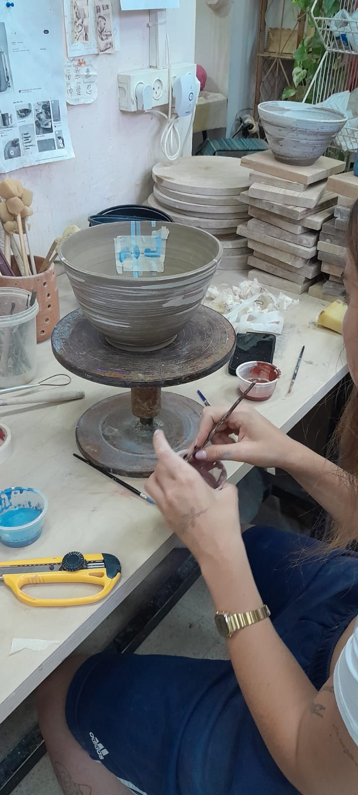 תלמידה מציירת על קערת קרמיקה בסטודיו