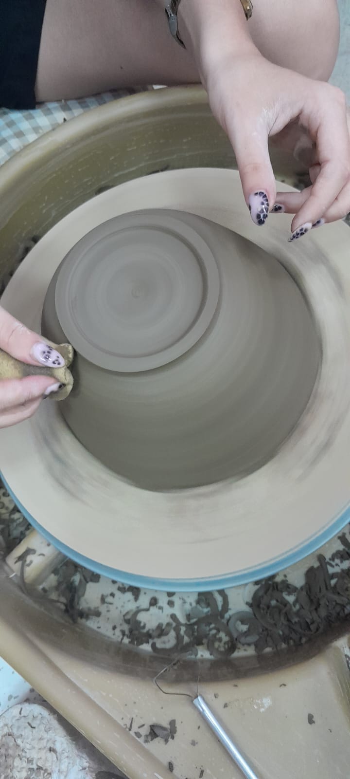 ידיים מעצבות קערת חרס על אובניים מסתובבים