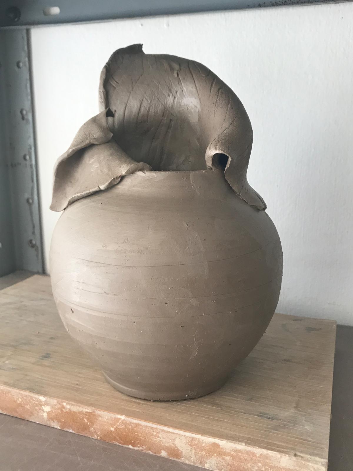 כד חרס עם עלה גדול מעטר את חלקו העליון