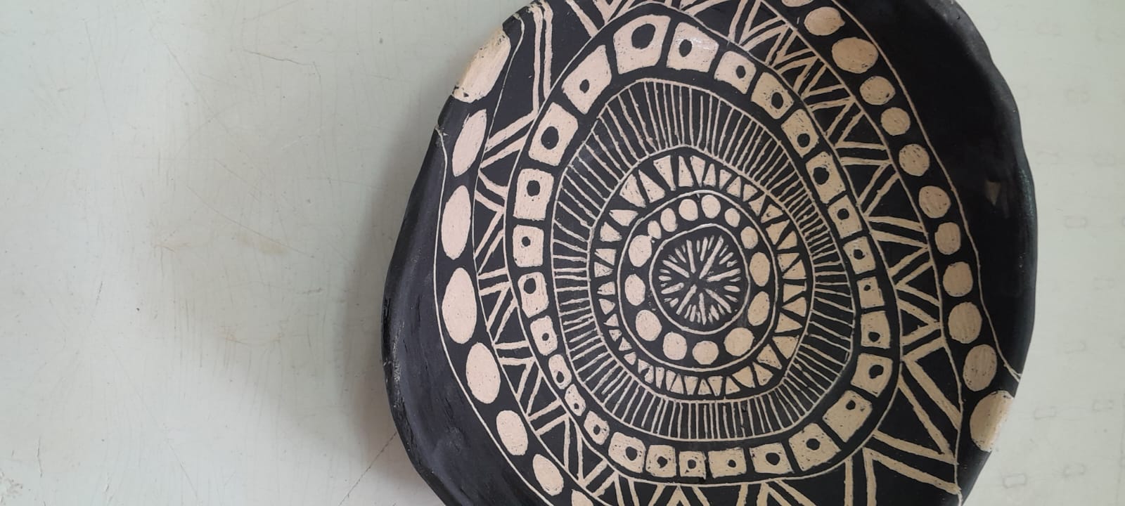 צלחת קרמיקה שחורה עם עיטורי מנדלה לבנים